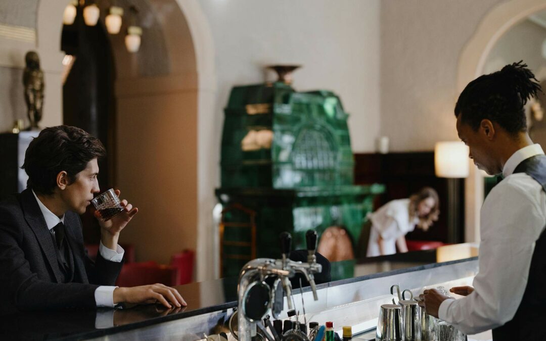 Un homme boit un café accoudé au bar